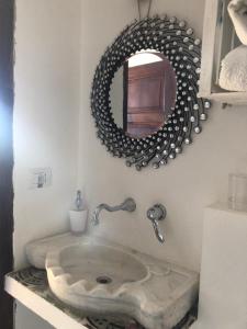 a bathroom with a stone sink and a mirror at Le Stanze sul Mare in Portoferraio