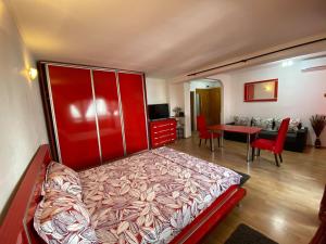 ein Schlafzimmer mit einem roten Bett und ein Wohnzimmer in der Unterkunft Faleză nord in Constanţa