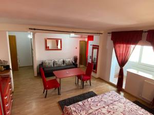 ein Wohnzimmer mit einem roten Tisch und einem Sofa in der Unterkunft Faleză nord in Constanţa