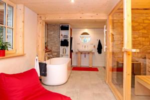 baño con bañera grande y lavamanos en Ferienhaus Haldenmühle - traumhafte Lage mitten in der Natur mit Sauna, en Simonswald