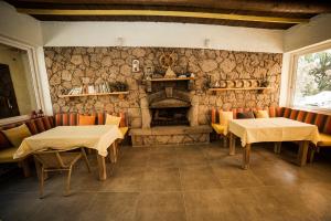 um restaurante com duas mesas e uma lareira de pedra em Limonata Hotel Assos em Behramkale
