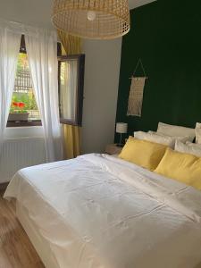 un grande letto bianco in una camera da letto con parete verde di Casa Di Famiglia a Salonicco