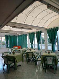 a dining room with green tables and chairs at Verde Mare in Silvi Marina