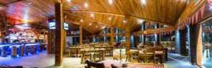 a restaurant with tables and chairs in a building at Gorący Potok Apartamenty in Szaflary