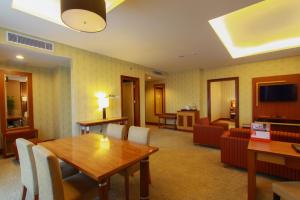 uma sala de estar com mesa e cadeiras em Swiss-Belhotel Maleosan Manado em Manado