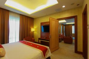 um quarto de hotel com uma cama e uma televisão em Swiss-Belhotel Maleosan Manado em Manado
