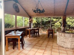 a dining room with a table and a stone fireplace at Hôtel-Restaurant La Bergerie in Sévérac d' Aveyron