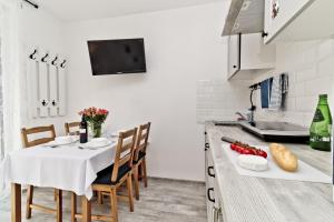 a kitchen with a table with a white table cloth at Apartamenty In Chałupy Kaperska in Chałupy