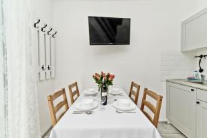 a dining room table with a white table cloth and chairs at Apartamenty In Chałupy Kaperska in Chałupy