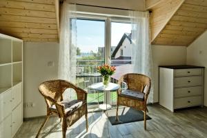 Pokój ze stołem, krzesłami i oknem w obiekcie Apartamenty.in Chałupy Kaperska w Chałupach