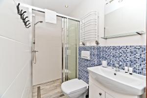 W łazience znajduje się umywalka i prysznic. w obiekcie Apartamenty.in Chałupy Kaperska w Chałupach