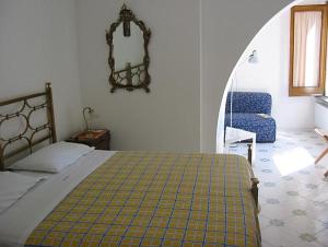 um quarto com uma cama, uma cadeira e um espelho em Villa Casale Ravello Residence em Ravello