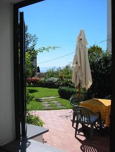 eine Terrasse mit einem Sonnenschirm, einem Tisch und Stühlen in der Unterkunft Villa Casale Ravello Residence in Ravello