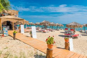 a beach with chairs and umbrellas and the ocean at Iris Beach Hotel in Sveti Vlas