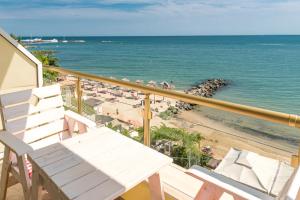 a balcony with a bench and a beach at Iris Beach Hotel in Sveti Vlas