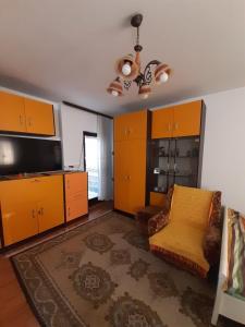 - un salon avec des armoires orange et un canapé dans l'établissement Apartmani Perovic, à Sokobanja