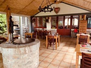 a restaurant with a large room with tables and chairs at Hôtel-Restaurant La Bergerie in Sévérac d' Aveyron