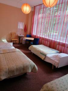 a hotel room with two beds and a table and chairs at Minhauzena Unda in Saulkrasti