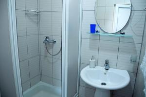 a bathroom with a sink and a shower with a mirror at Apartments Vila Vrdnik in Vrdnik