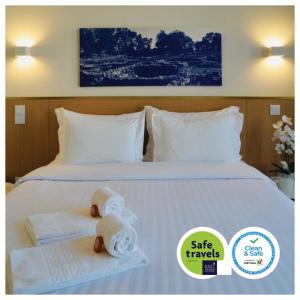 a hotel room with a bed with towels on it at ó Poboa Guesthouse in Póvoa de Varzim