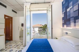 a bedroom with a bed and a view of the ocean at Hotel La Meridiana in Sorrento