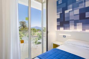 a bedroom with a bed and a balcony at Hotel La Meridiana in Sorrento