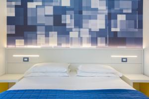 a bedroom with a bed with a blue and purple wall at Hotel La Meridiana in Sorrento