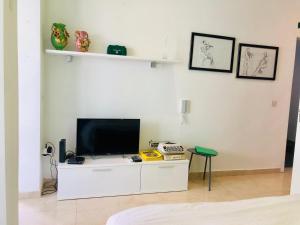 soggiorno con TV su un armadietto bianco di Valletta Dream Suites a La Valletta