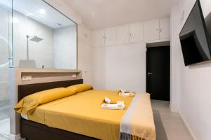 a bedroom with a yellow bed and a television at Unique House - Private SPA&Pool -StayInSeville in Seville