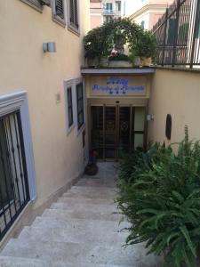 wejście do budynku z drzwiami i roślinami w obiekcie Hotel Principe Di Piemonte w Rzymie