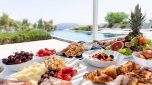a table with many different types of food on it at Mykonos Unique Villas in Kalafatis