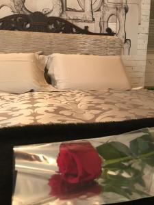 a red rose is sitting on a bed at Suite Romantica Fuga in Roncone