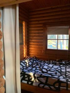 a bedroom with a bed in a log cabin at Velkuanmaa Lomamökki in Naantali