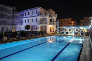 a swimming pool in front of a hotel at night at Sunset Village in Didim