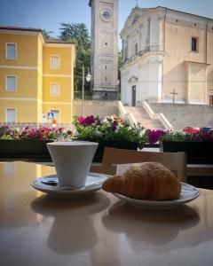 una taza de café y una pastelería en una mesa en Caffè Martini en Arsiero