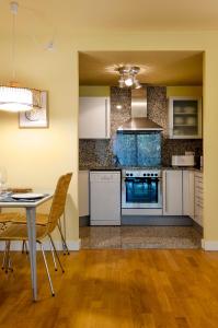 une cuisine avec des placards blancs et une table avec des chaises dans l'établissement Devesa Park Apartment with Private Parking, à Gérone