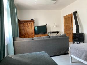 a living room with a couch and a television at Chalupa Spoko Liptov in Trstené