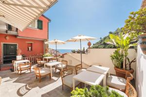 a patio with tables and chairs and the ocean in the background at La Torretta Lodge in Manarola