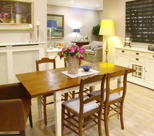 eine Küche und ein Wohnzimmer mit einem Holztisch mit Blumen in der Unterkunft Ferienwohnung Zauberhaft in Schalkenmehren