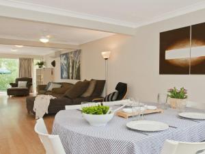 una sala de estar con una mesa y un sofá en Sea Whispers, en Callala Beach