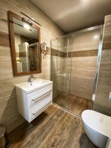 a bathroom with a white sink and a shower at Hotel Turist 98 in Jajce