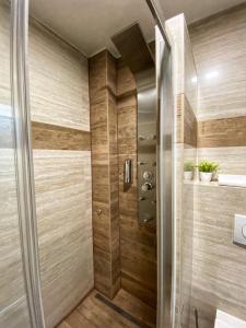 y baño con ducha y paredes de madera. en Hotel Turist 98, en Jajce