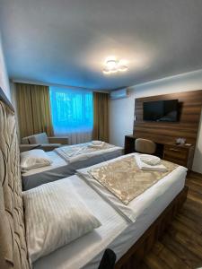 a hotel room with two beds and a flat screen tv at Hotel Turist 98 in Jajce