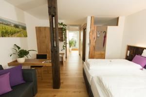 - une chambre avec un lit, un canapé et un bureau dans l'établissement IBY-LEHRNER WEIN-GUT und WEIN-Träumerei, à Horitschon