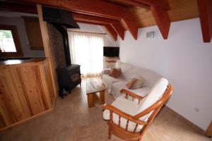 a living room with a white couch and a stove at Apartamento El Molino in Tramacastilla de Tena