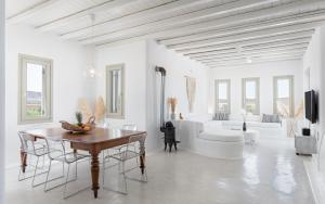a white living room with a table and a tub at Mykonos Unique Villas in Kalafatis