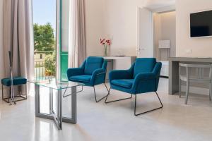 モンテカティーニ・テルメにあるグランド ホテル クローチェ ディ マルタのリビングルーム(青い椅子、ガラスのテーブル付)