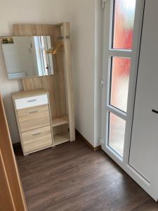 uma casa de banho com um espelho e uma cómoda e uma porta em Apartmány Krupka em Krupka