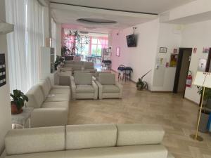 a living room with couches and chairs in a room at Hotel Continental in Pesaro