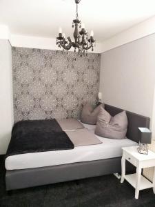 um quarto com uma cama grande e um lustre em Ferienwohnung FLAIR em Zella-Mehlis
